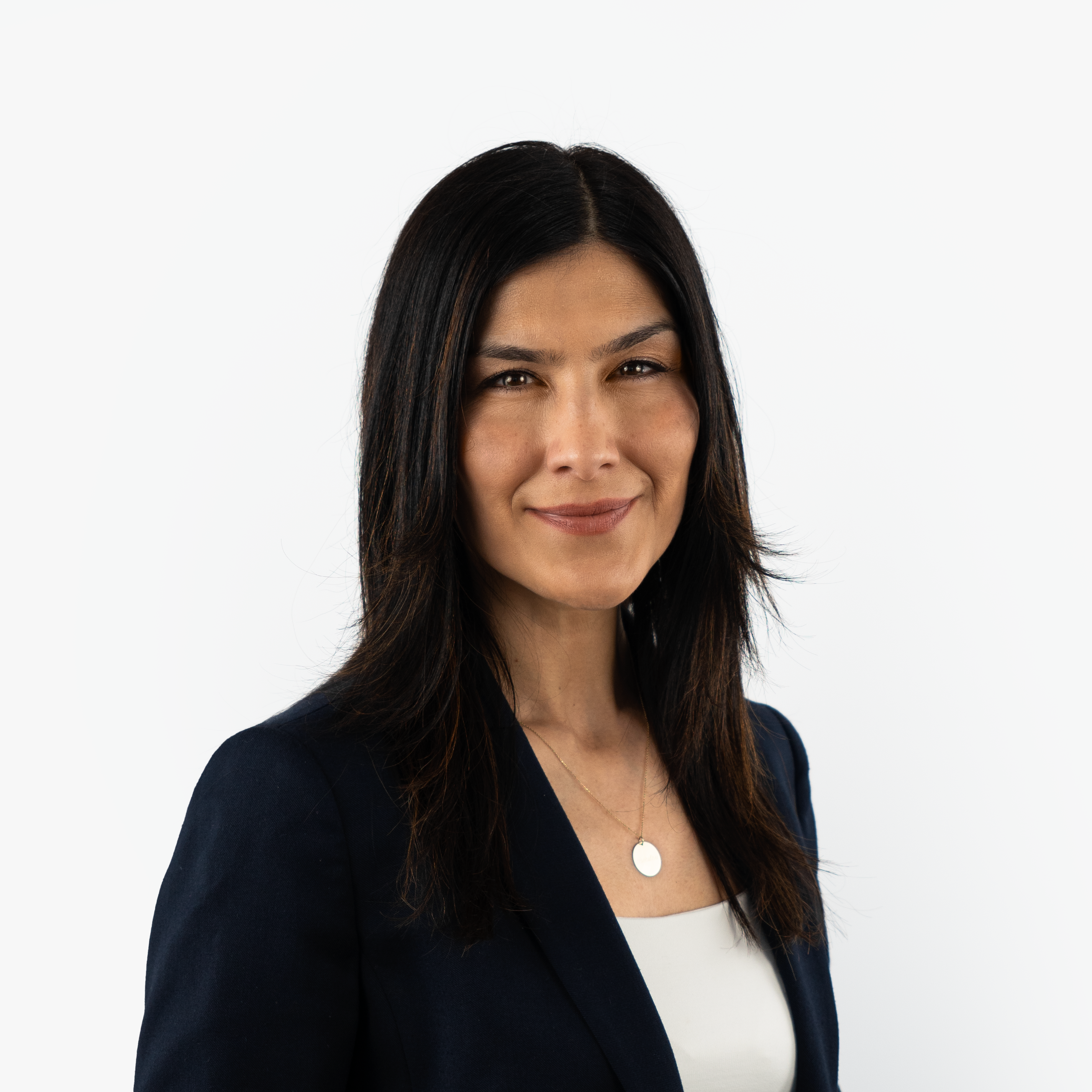 Porträt der Rechtsanwältin Ümüs Berk-Basalak. Eine Frau mit langen, dunklen Haaren und einem freundlichen Lächeln, gekleidet in einen dunklen Blazer und ein weißes Oberteil.